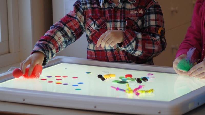 Barn på förskola vid ljusbord